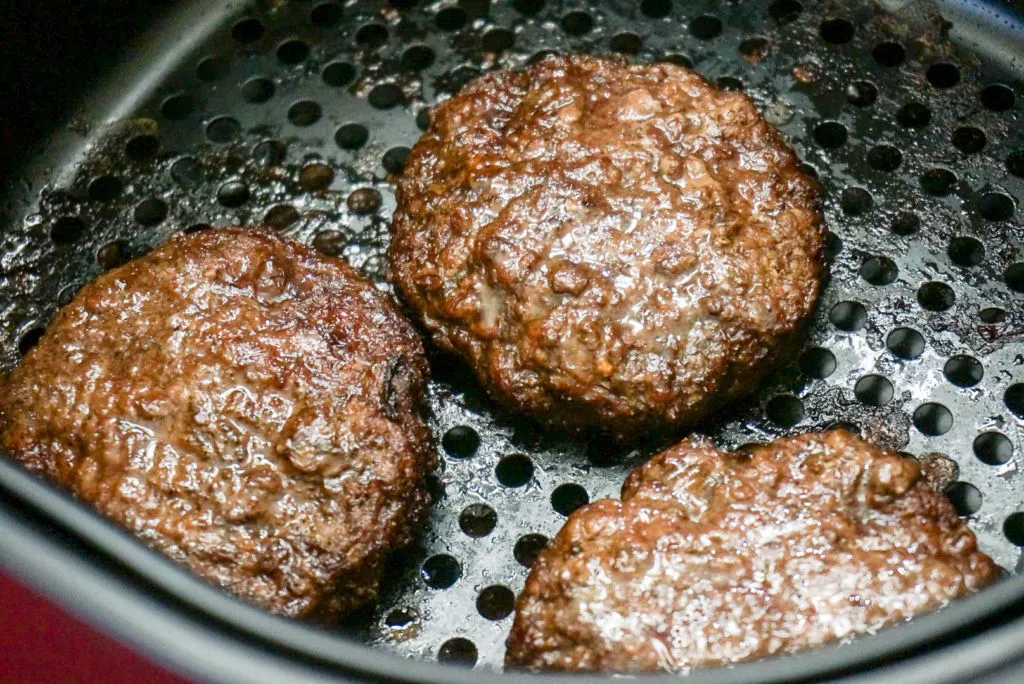 well done Air fryer hamburgers in basket of the air fryer