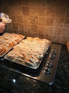 huge frosted cinnamon rolls on baking pans