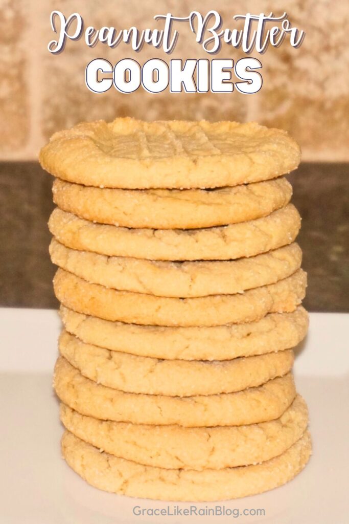 peanut butter cookies stacked up very tall on a white tray for serving