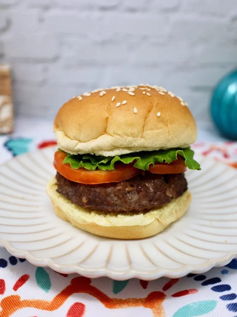 a hamburger cooked in the air fryer on a ruffled plate