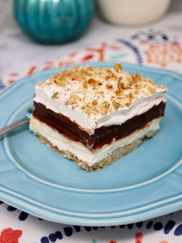 four layer delight topped with chopped pecans for a crunchy texture