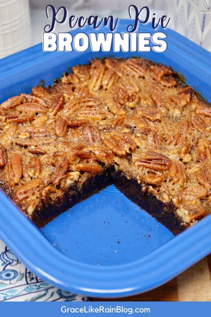 image of pecan pie brownies with a giant piece missing out of the middle of the pan and the words pecan pie brownies printed across the front