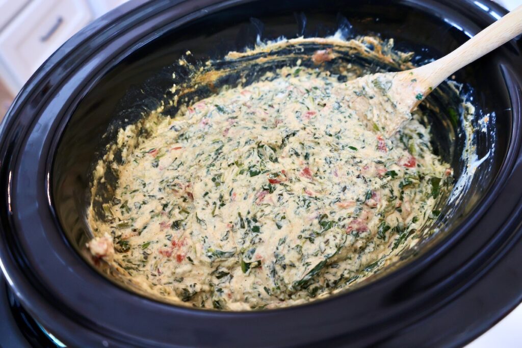 a crock pot full of fiesta spinach cheese dip