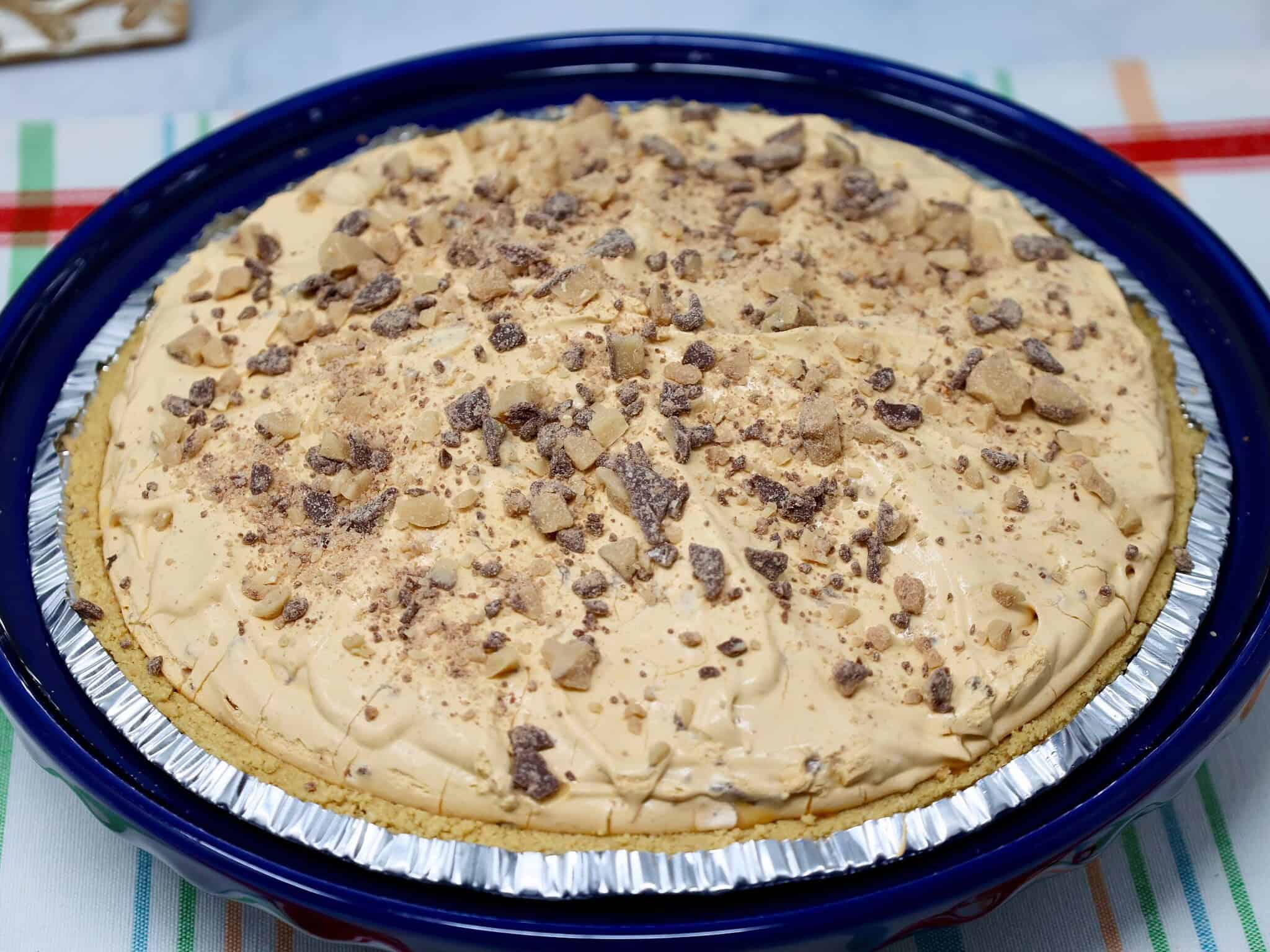 Close up of creamy butterscotch pie with whipped topping and toffee bits