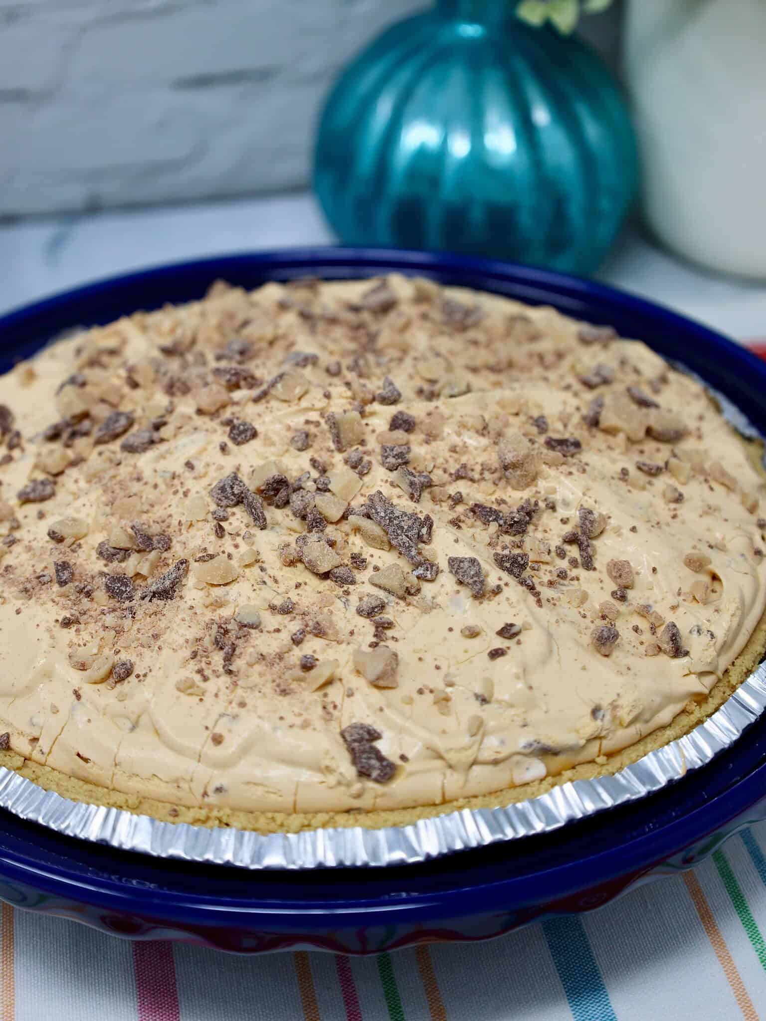Whole no bake butterscotch pie in graham cracker crust before slicing