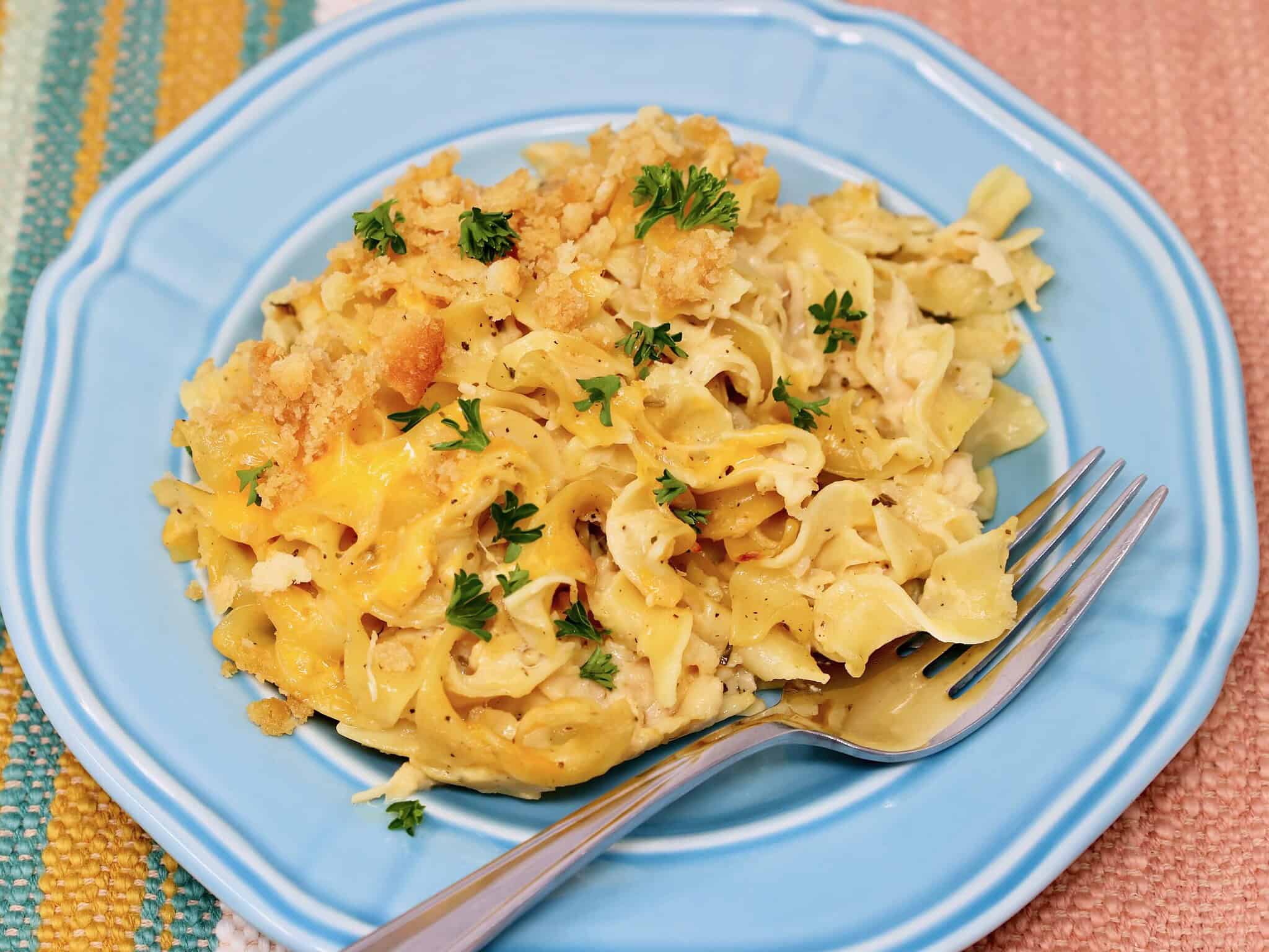 Serving of creamy canned chicken noodle casserole on light blue plate