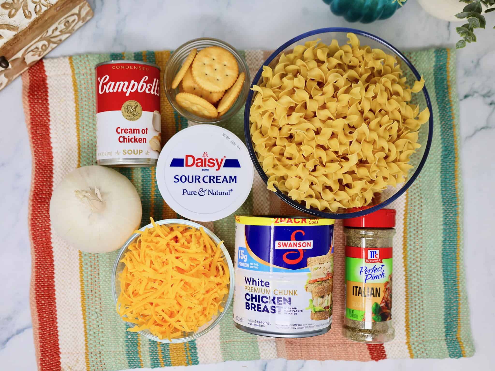 Ingredients for canned chicken noodle casserole including canned chicken, egg noodles, and cream soup