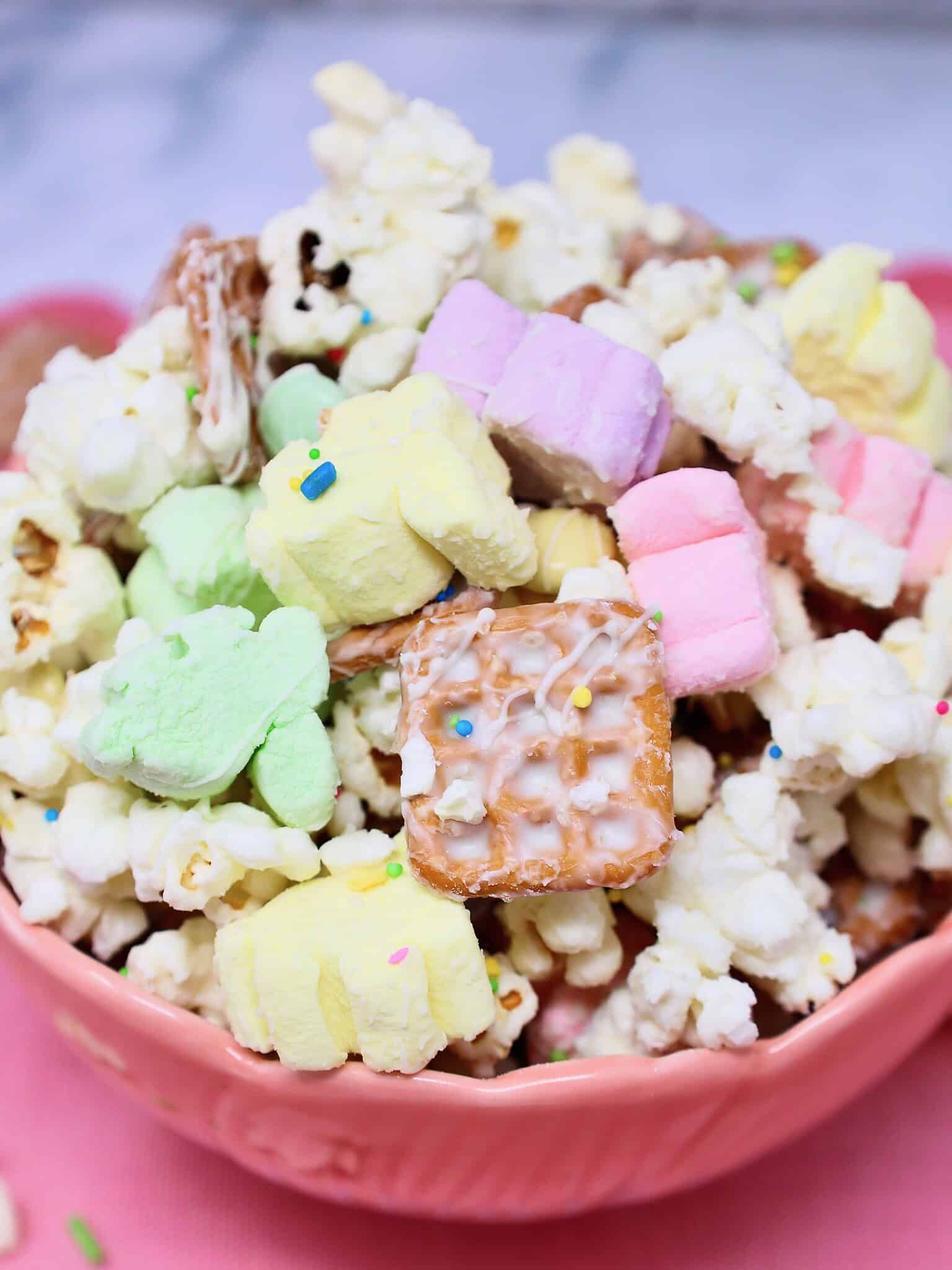 Sweet and salty Easter popcorn snack mix with white chocolate drizzle and pastel candy pieces