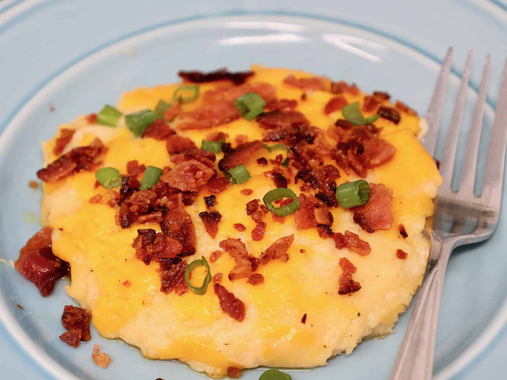 close up of creamy cheesy mashed potatoes casserole serving