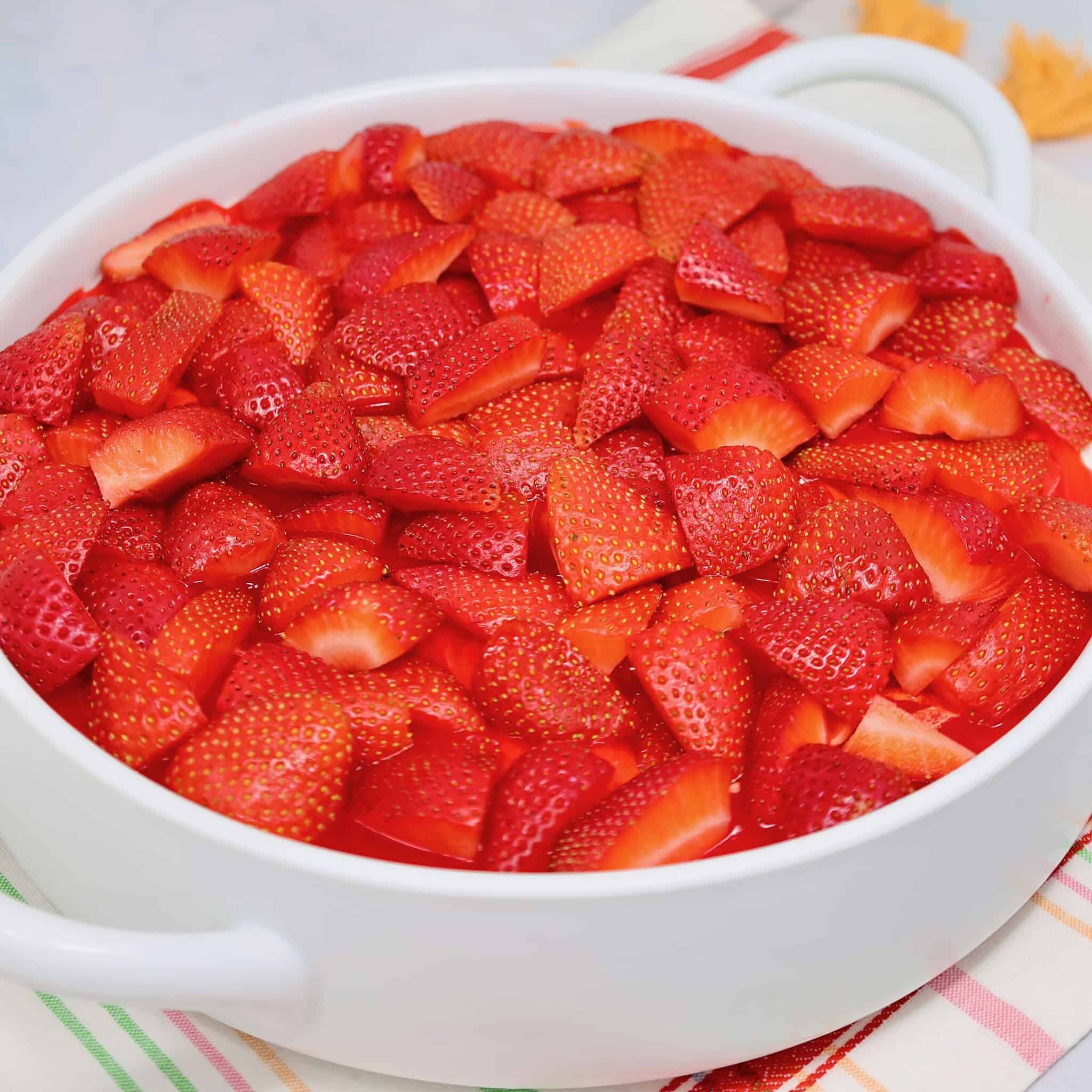 no bake layered strawberry dessert with fresh strawberries on top