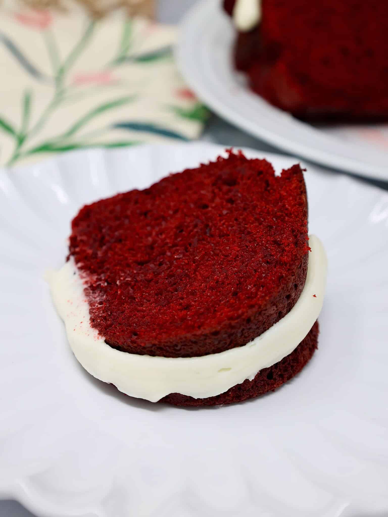 Slice of moist red velvet Bundt cake with cream cheese frosting