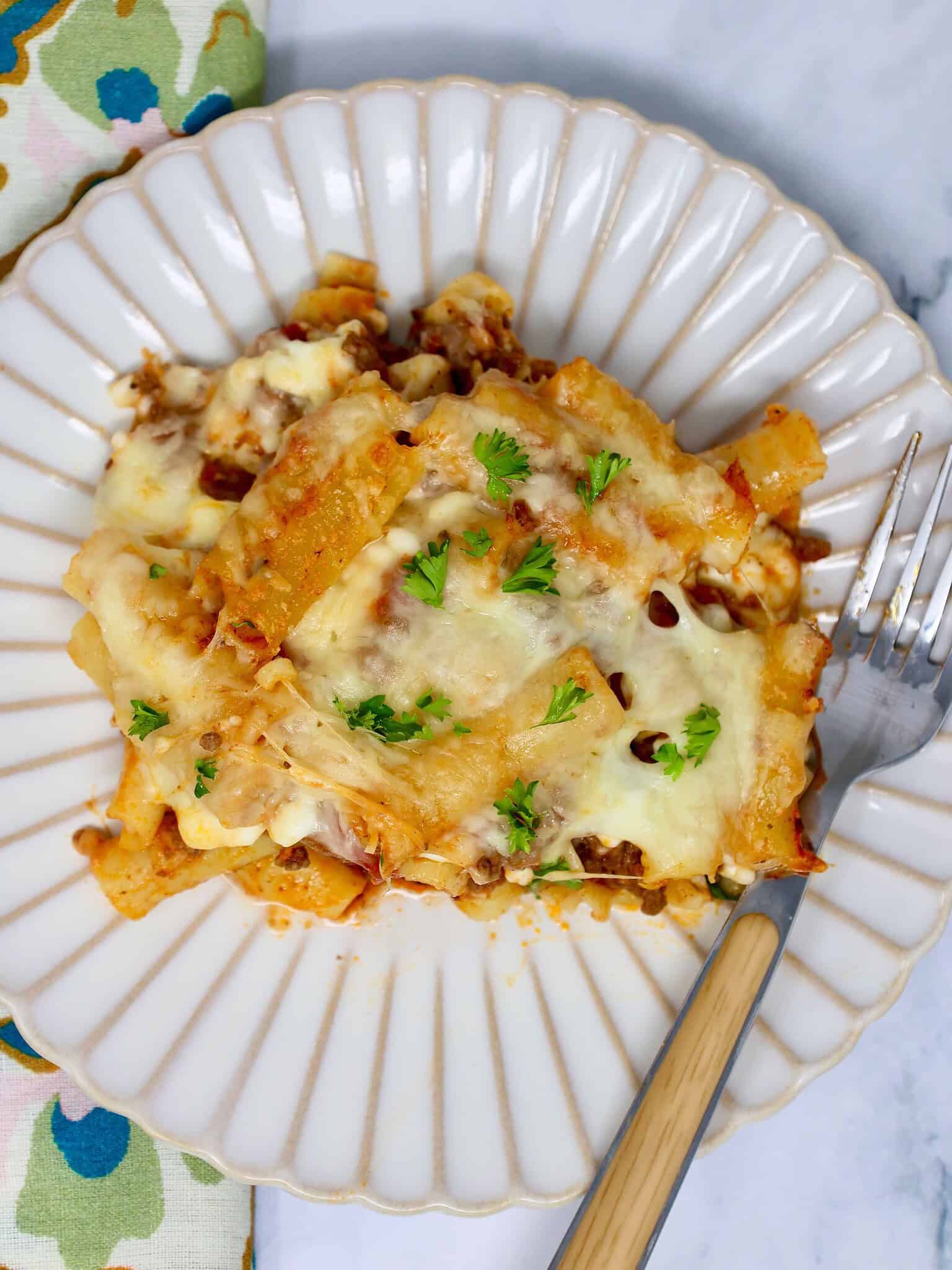 Scoop of cheesy baked ziti with cottage cheese on a dinner plate