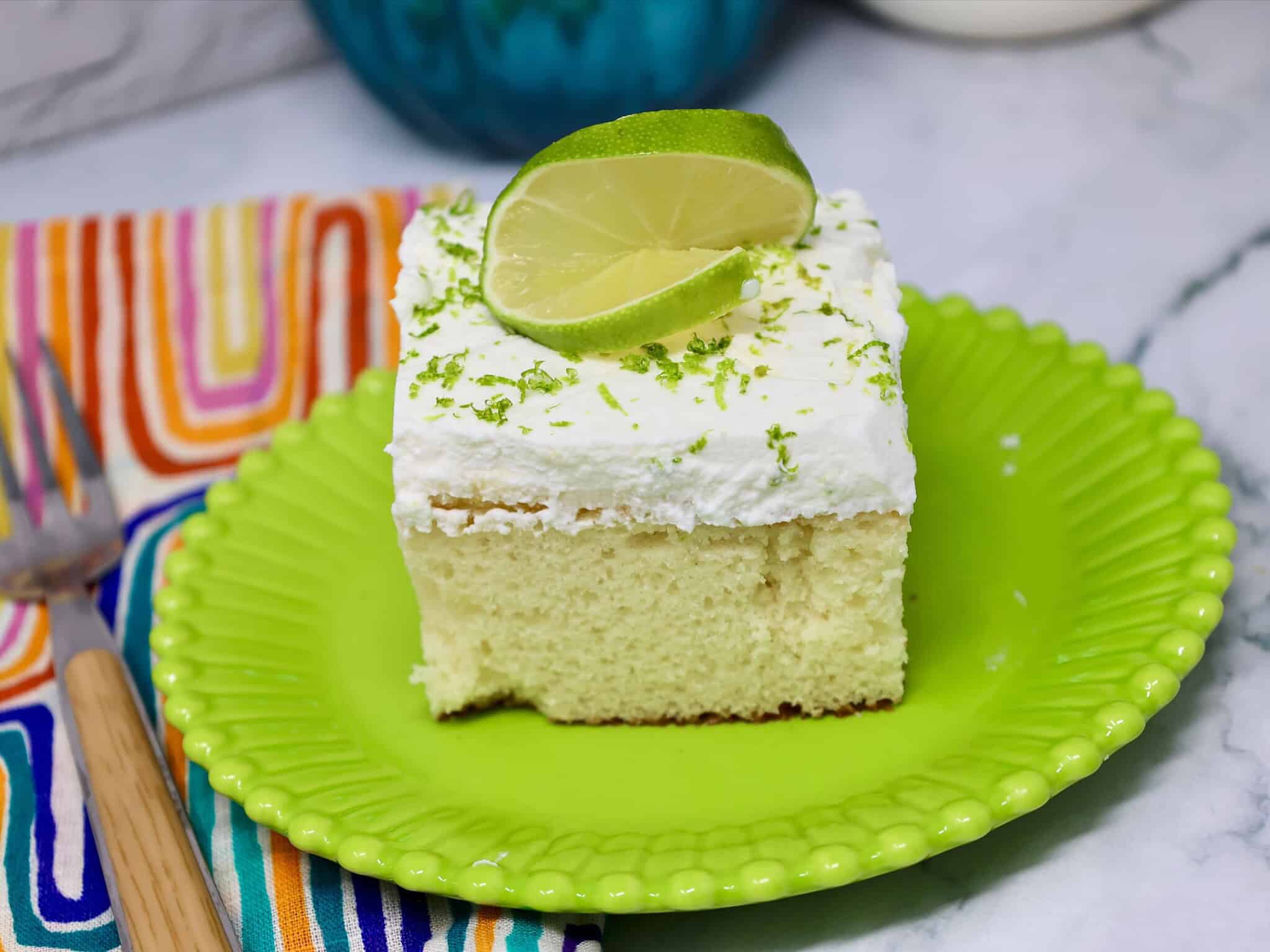 key lime poke cake with condensed milk and whipped topping ready to serve
