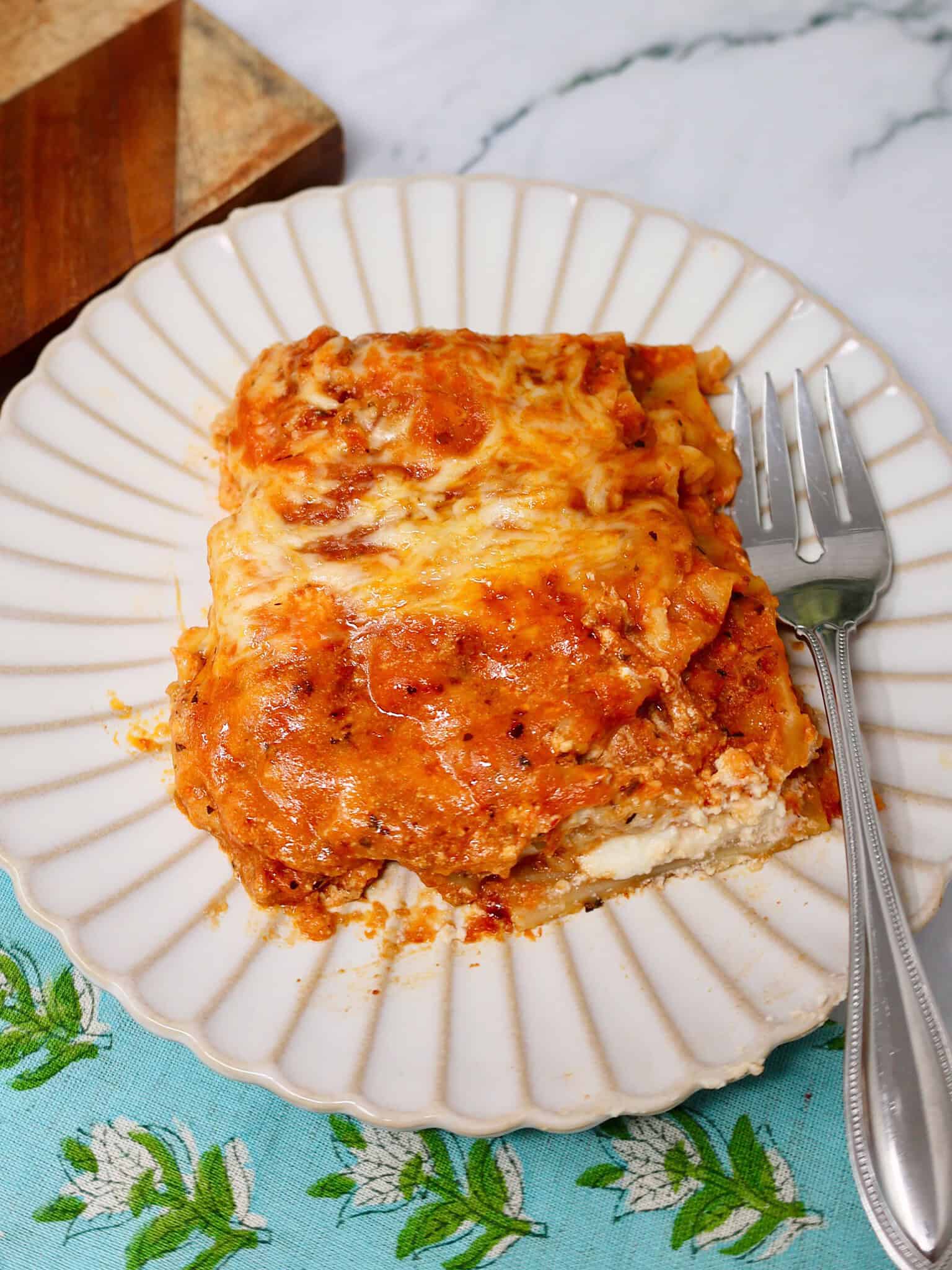 Easy lazy lasagna recipe served on a white plate with meatballs and cheese