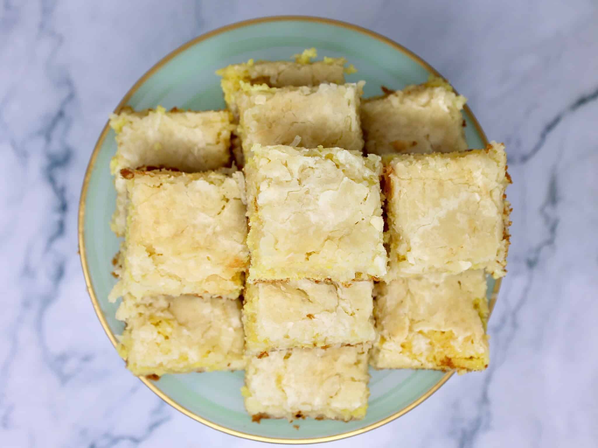 Close up of a lemon coconut bar showing gooey cream cheese filling and toasted coconut flakes