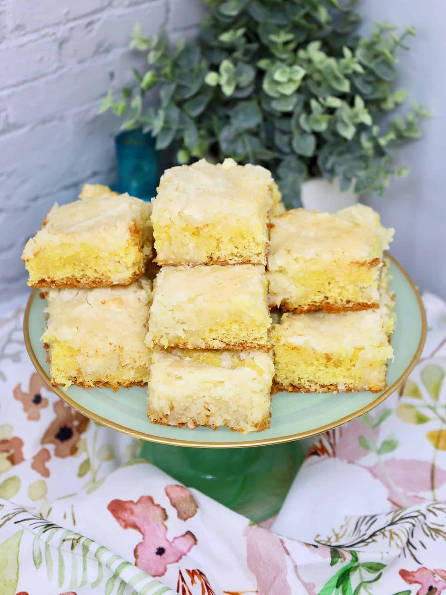 Lemon coconut bars on a wooden serving board dusted with powdered sugar perfect for spring brunch or potluck