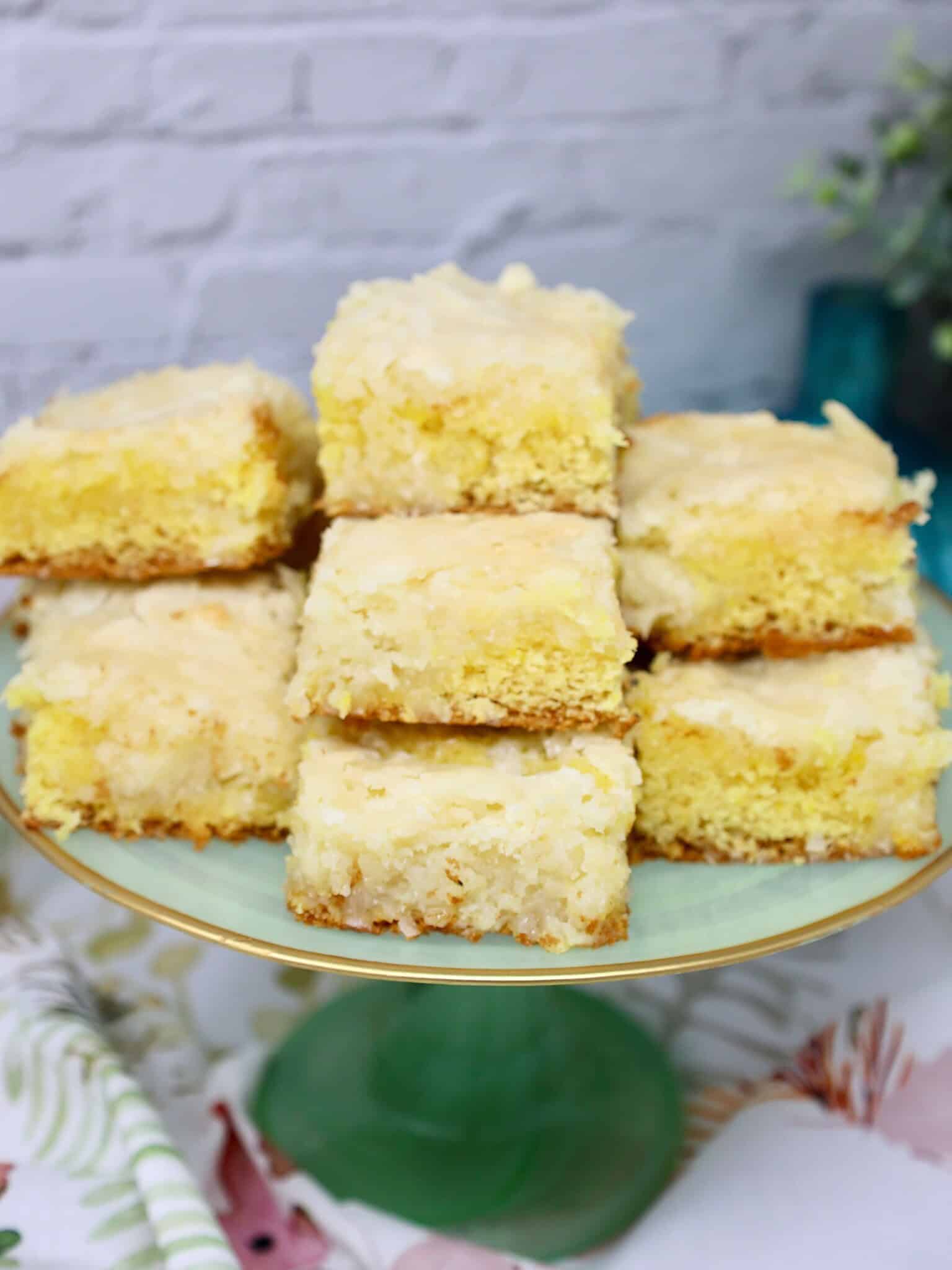 Overhead view of lemon coconut bars sliced into squares from a parchment lined baking dish