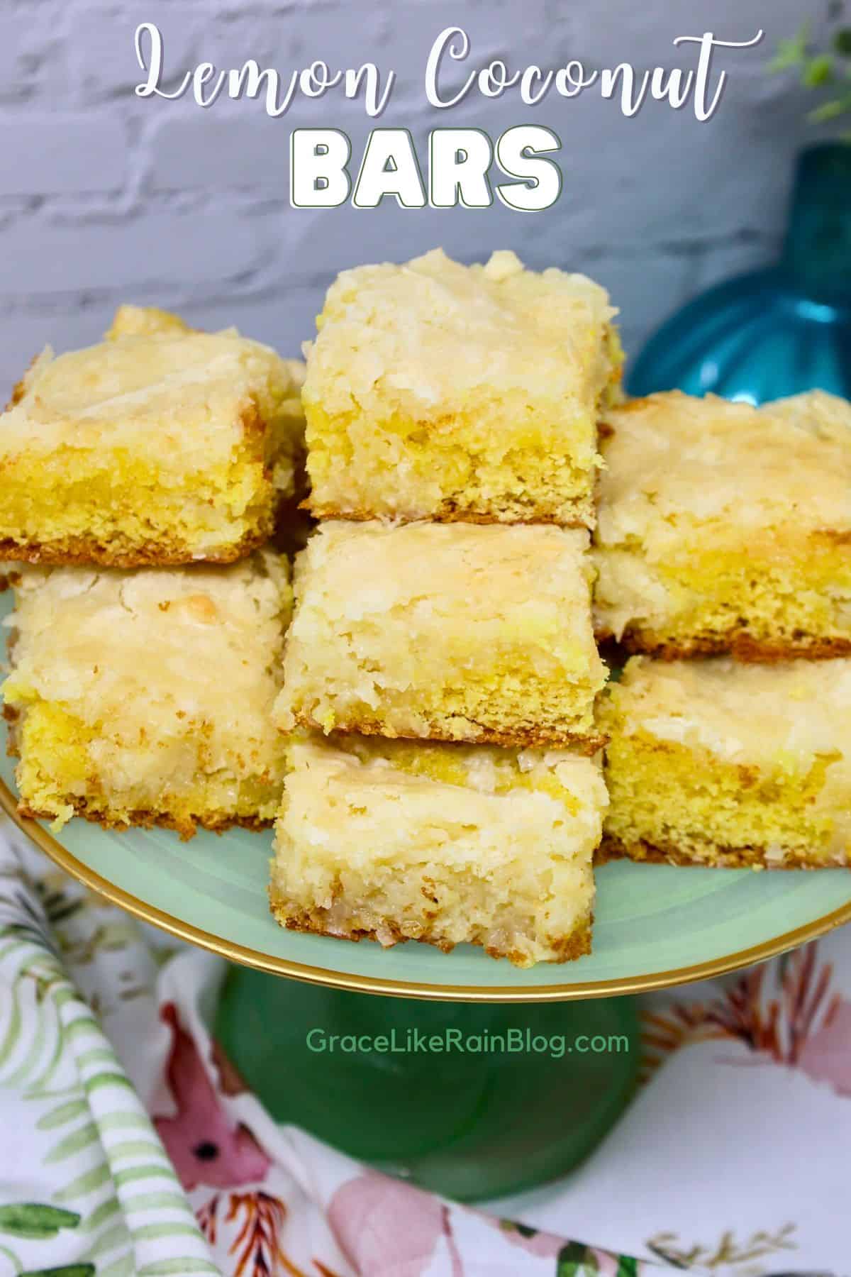 Lemon coconut bars stacked on a white plate with golden edges and gooey coconut filling
