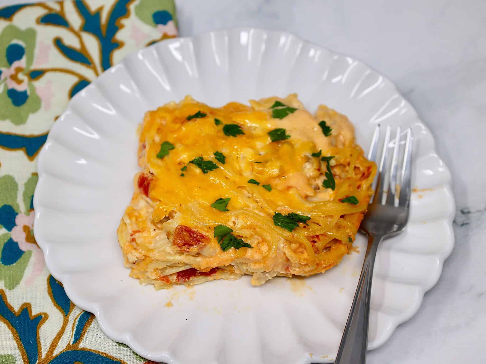 Close up of creamy chicken spaghetti casserole with shredded rotisserie chicken and melted cheese