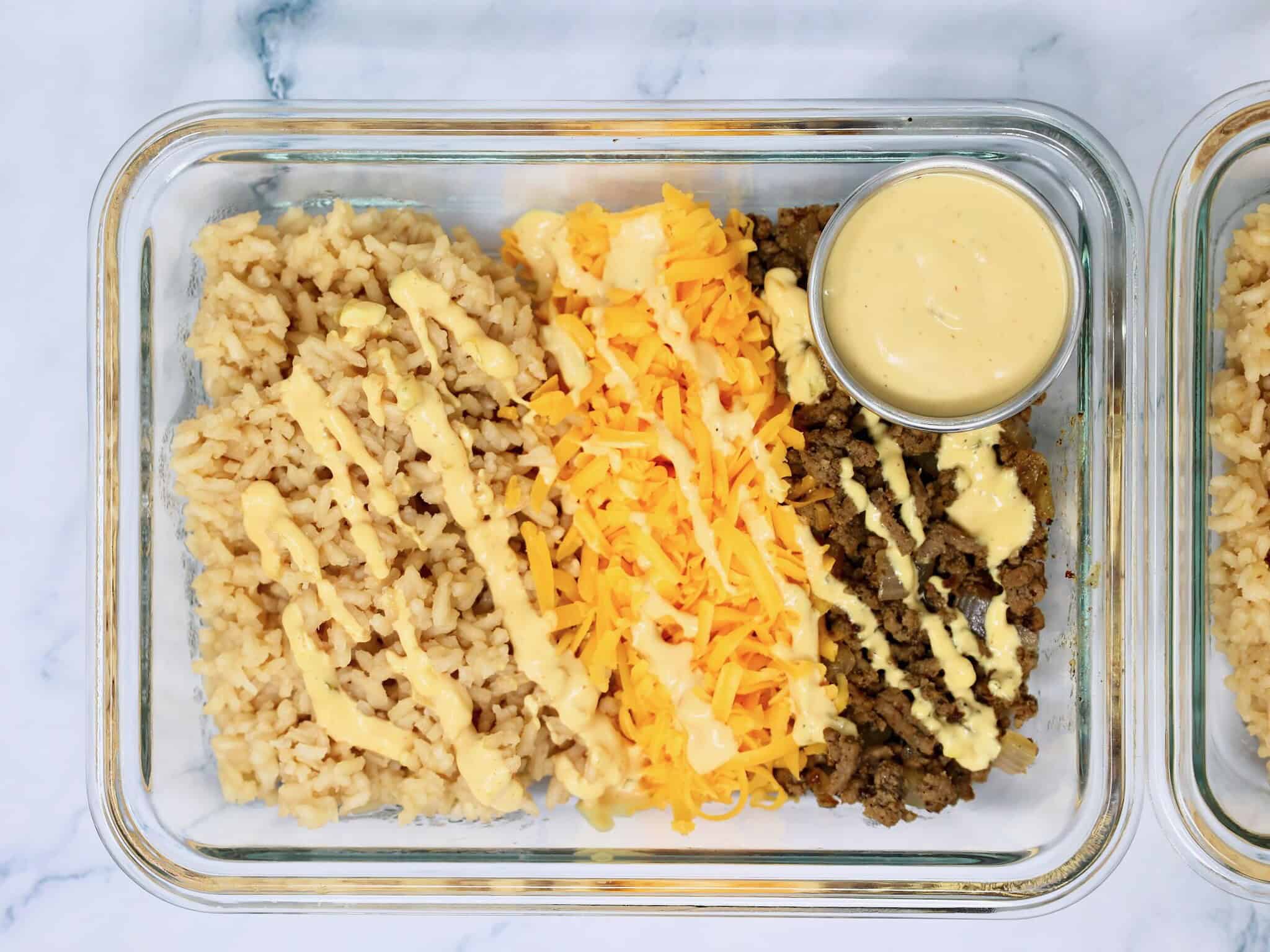 Cheeseburger Rice Bowls with seasoned ground beef, fluffy rice, cheddar cheese, burger sauce, pickles, lettuce, and tomatoes