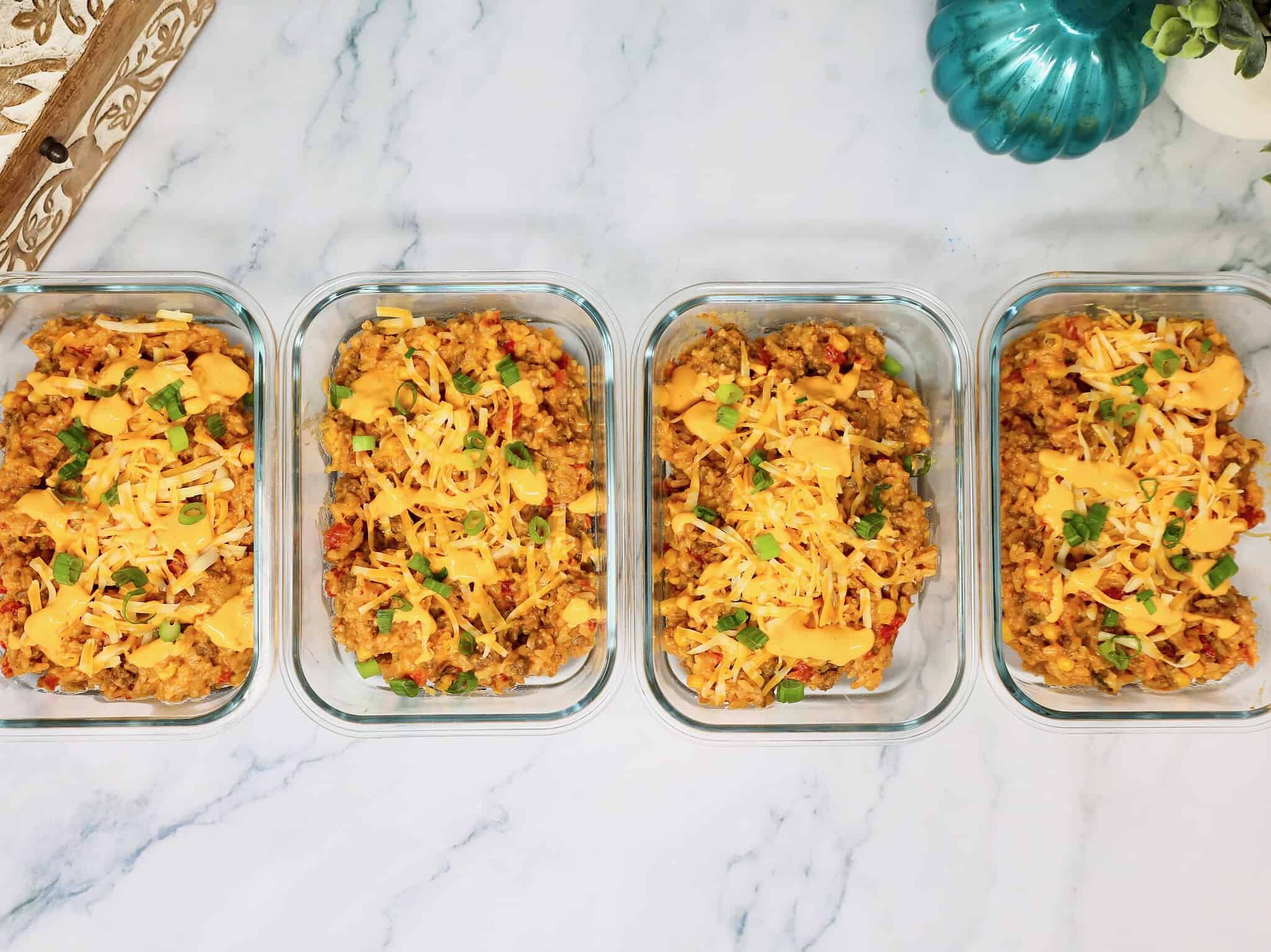 Ground Beef Queso Rice Bowls portioned into meal prep containers for easy lunches