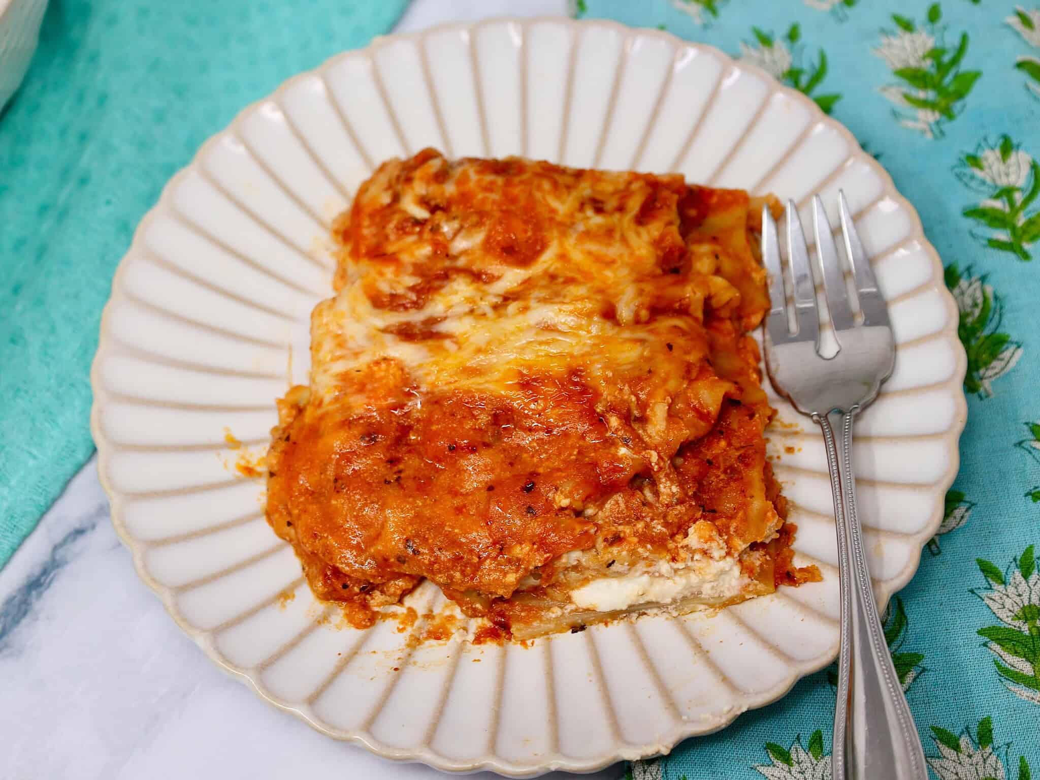 Slice of lazy lasagna on a dinner plate with melted cheese and meatballs