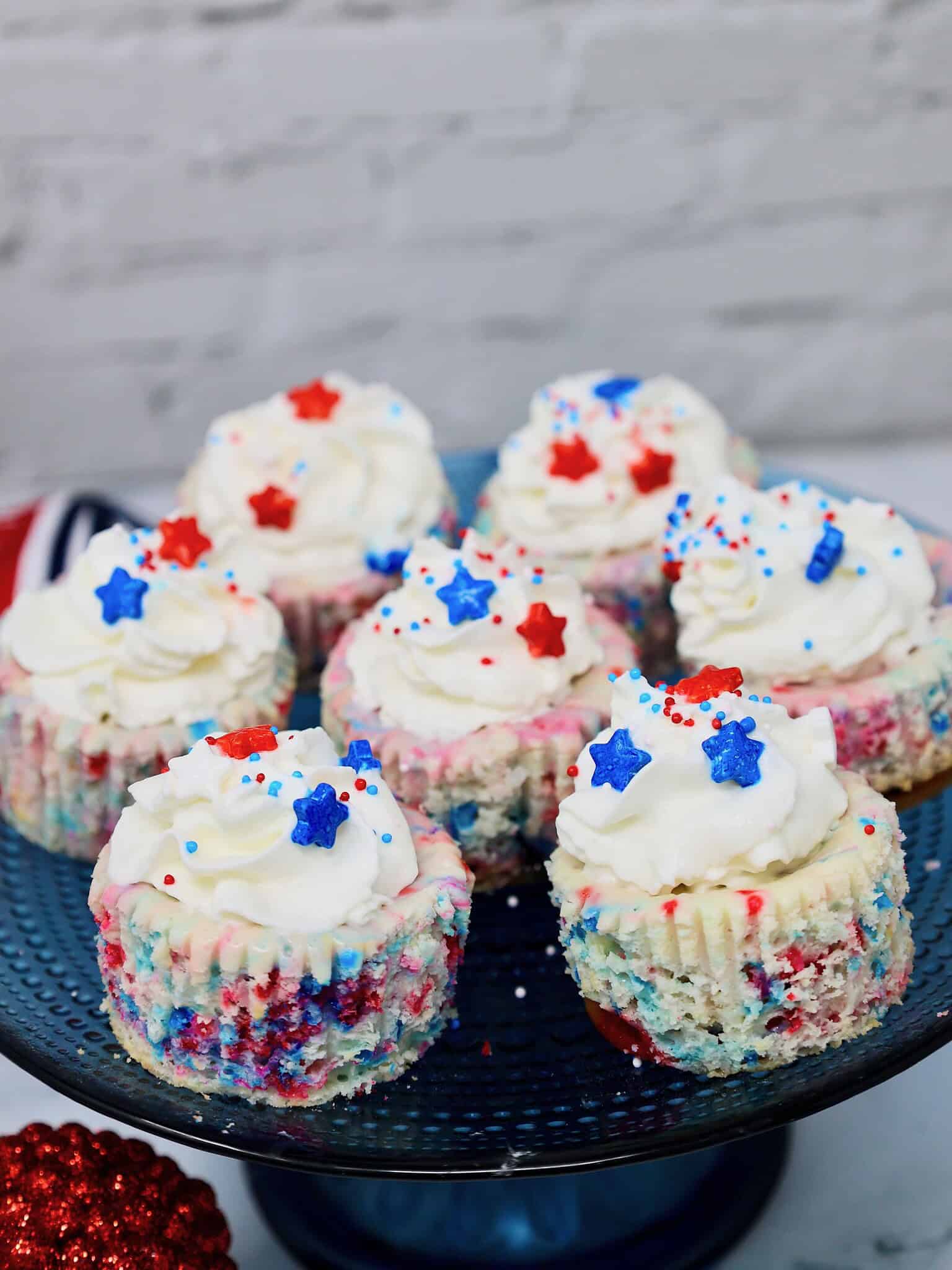 Patriotic mini cheesecakes in cupcake liners with creamy cheesecake filling and colorful sprinkles