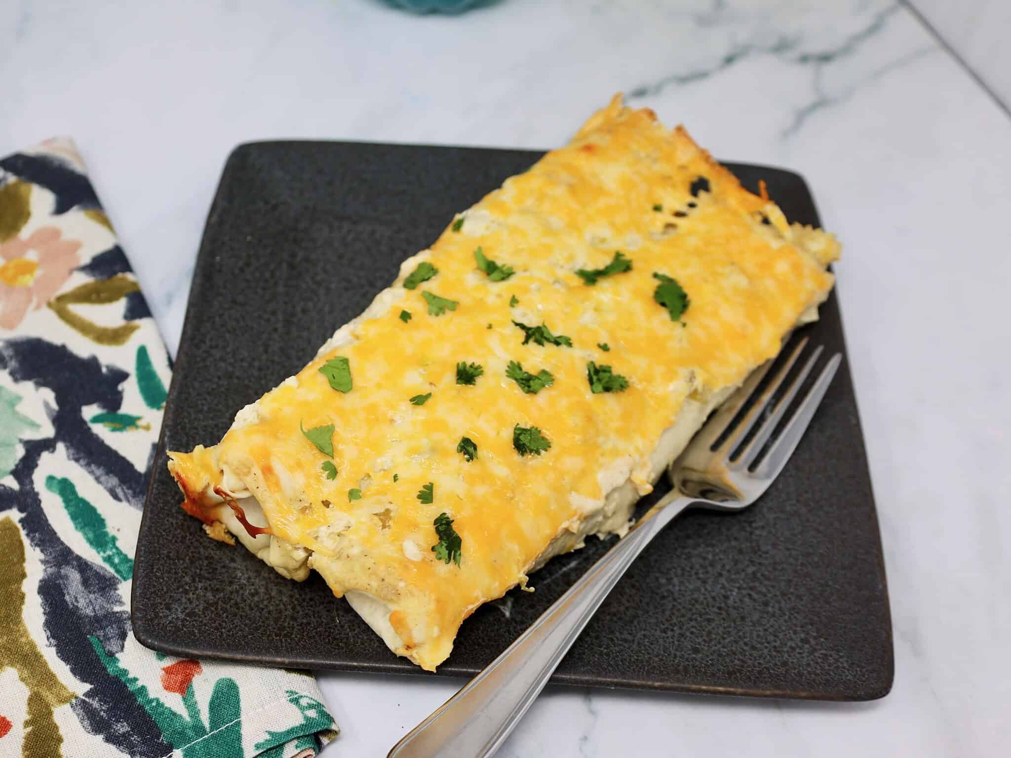 Creamy chicken enchiladas with salsa verde and green chiles served for dinner