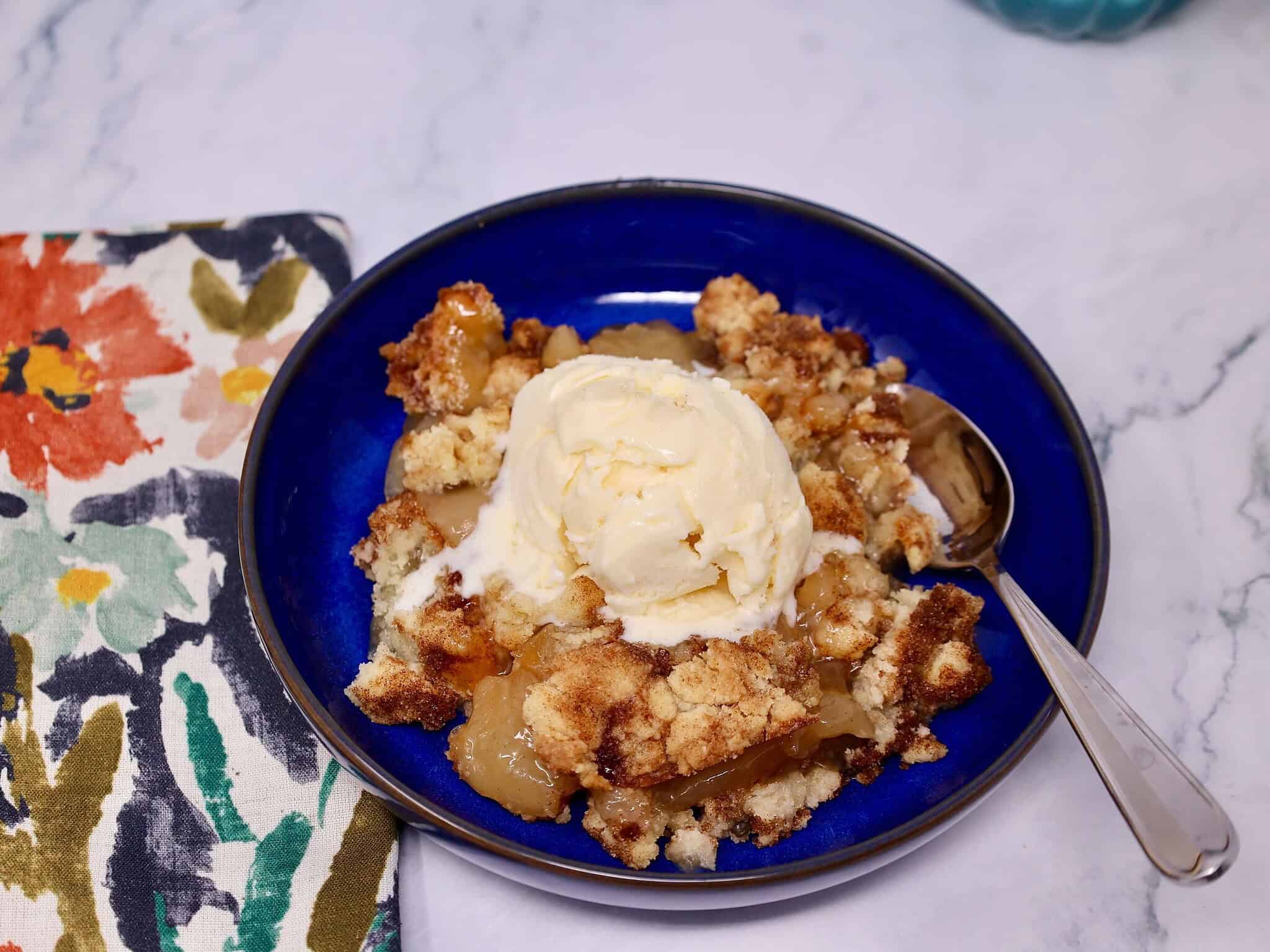 Scoop of snickerdoodle apple crisp showing soft apple filling and a buttery cinnamon cookie topping.