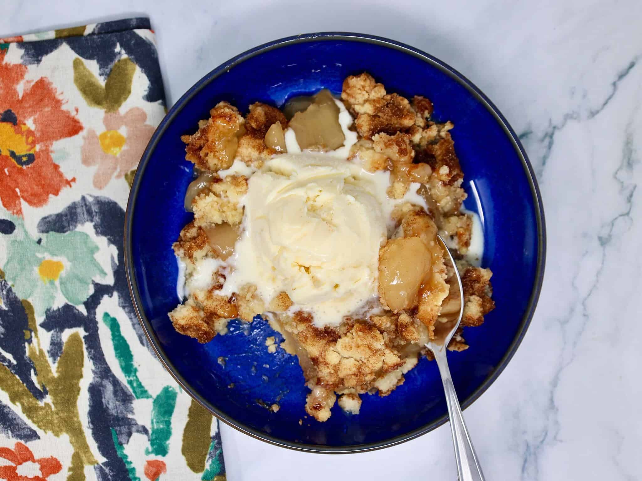 Close-up of easy apple crisp with a soft snickerdoodle cookie topping and sweet apple filling.