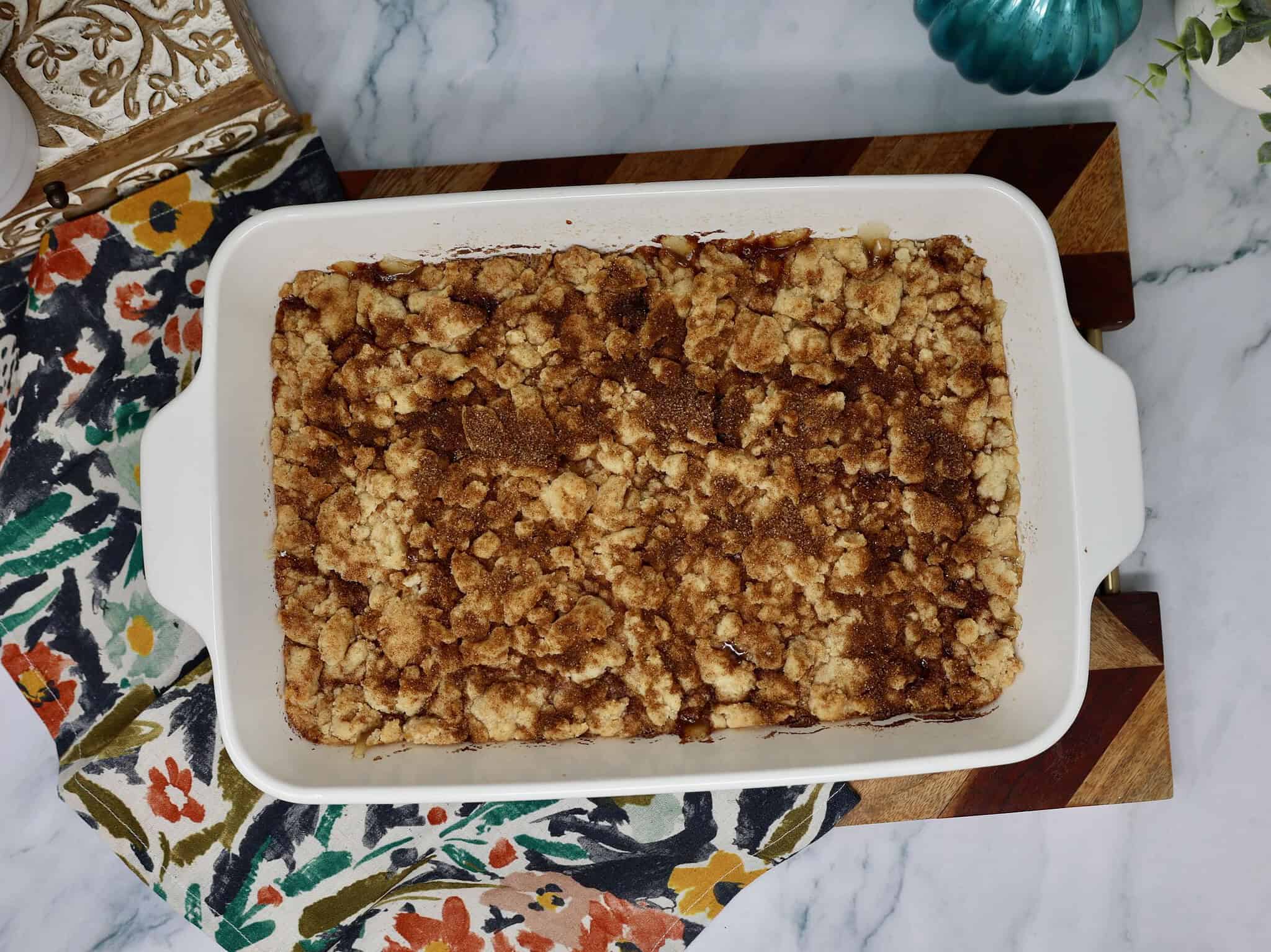 Baked snickerdoodle apple crisp with bubbly apple filling and a golden brown cookie crumble topping.