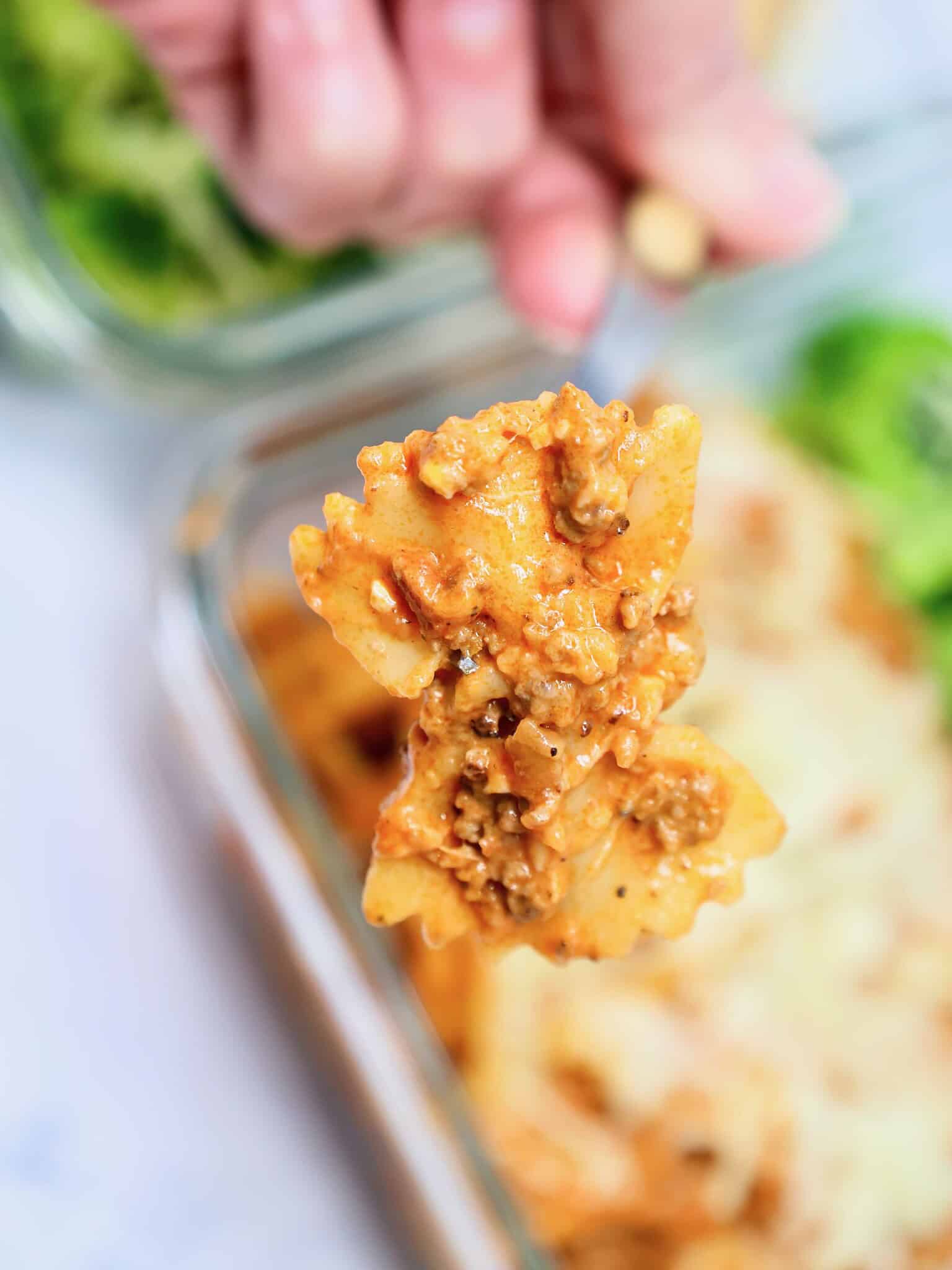 Forkful of creamy beef bowtie pasta with melted mozzarella cheese
