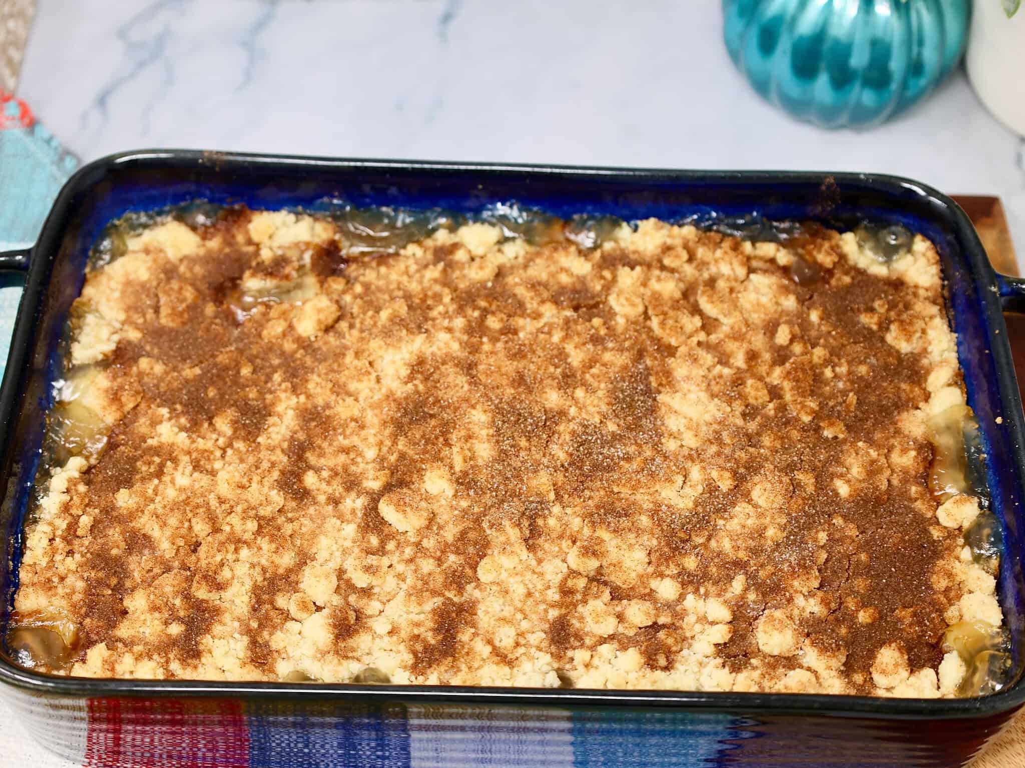 Snickerdoodle peach crisp with golden cookie topping and bubbling peach filling