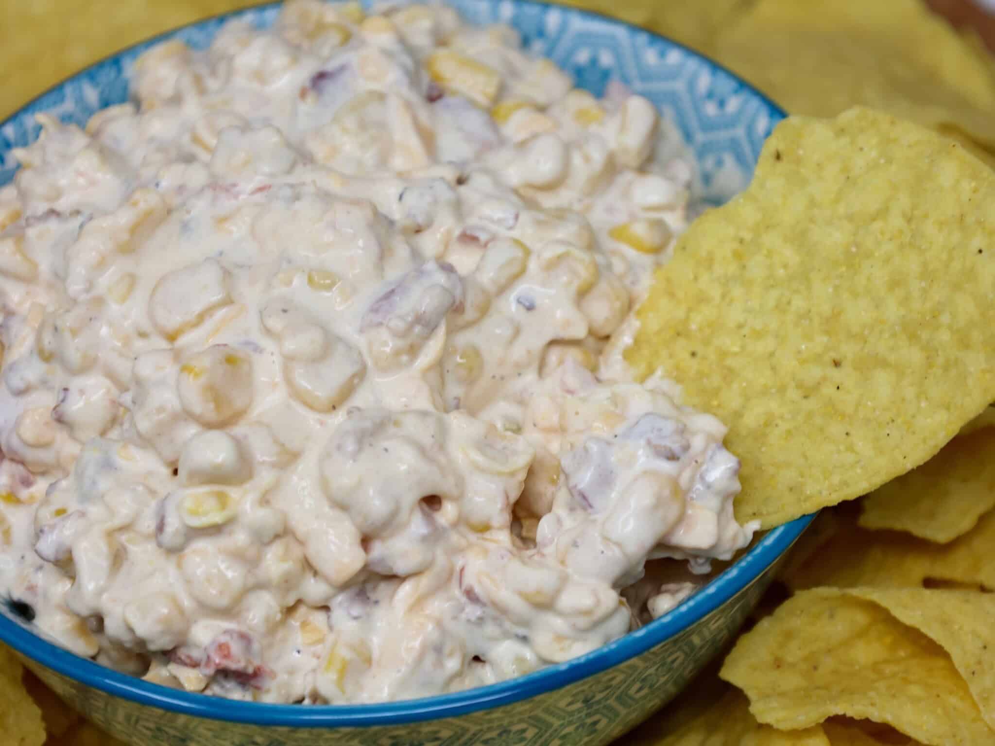 Bowl of creamy corn dip with bacon and cheddar ready for serving