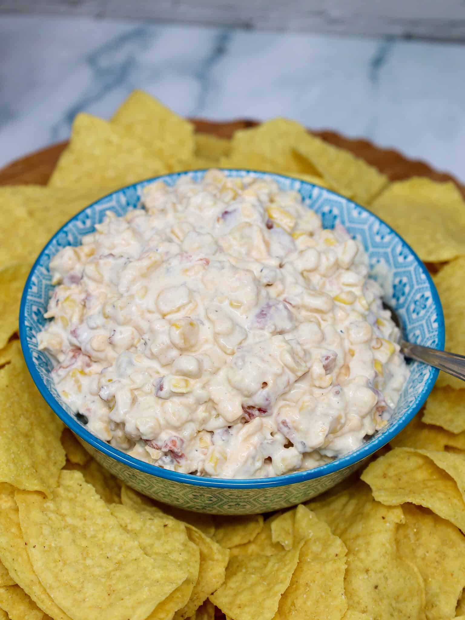 Bacon cheddar corn dip served in a bowl with tortilla chips