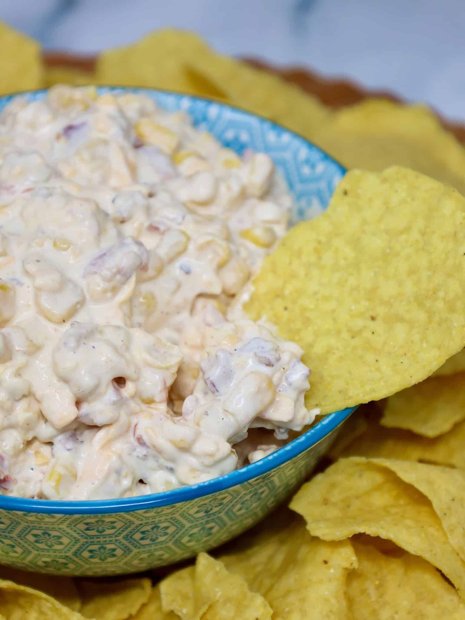 Easy cold corn dip garnished with crispy bacon, sharp cheddar, and green onions