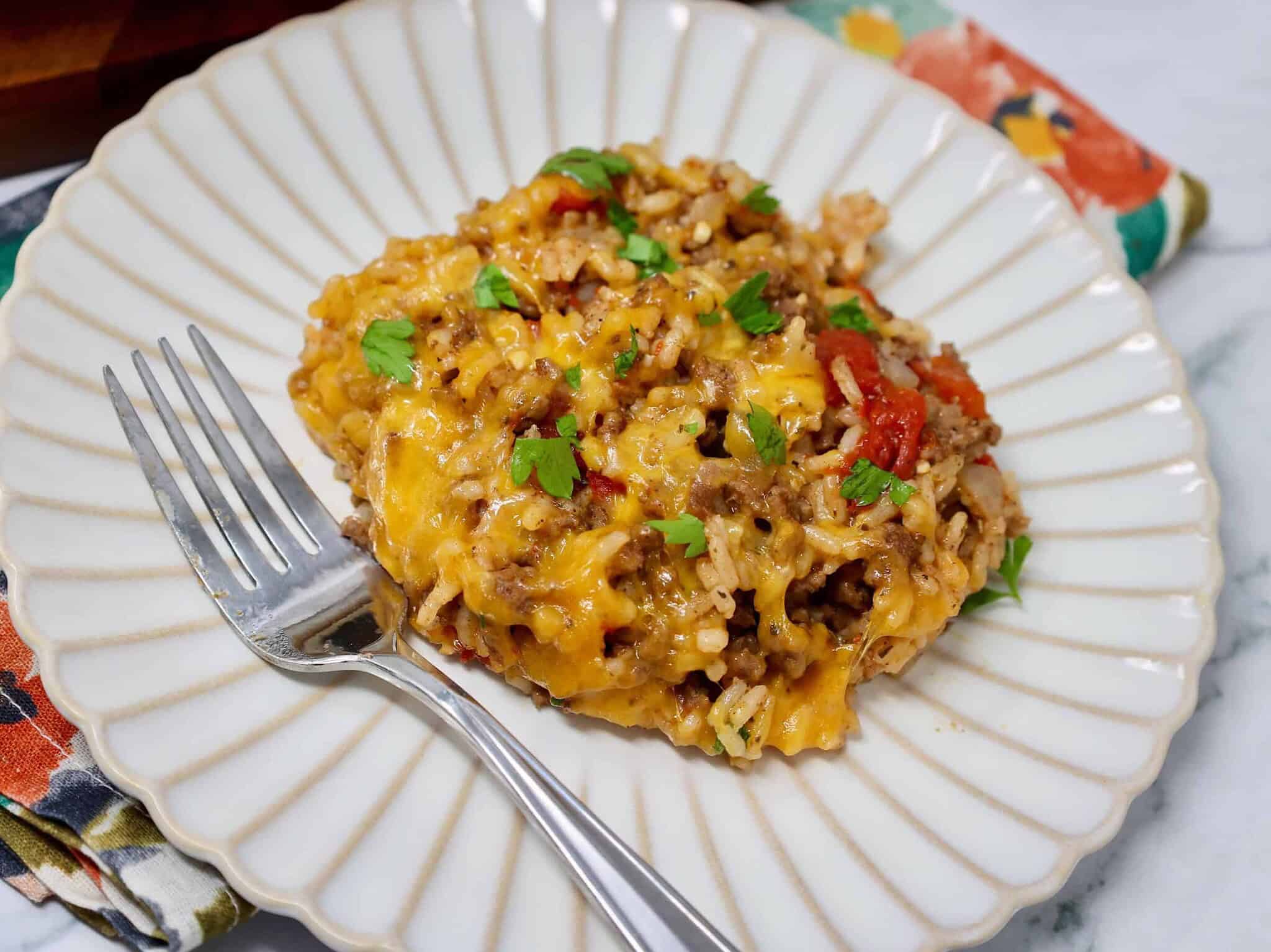 Serving of cheesy ground beef and rice on a white plate