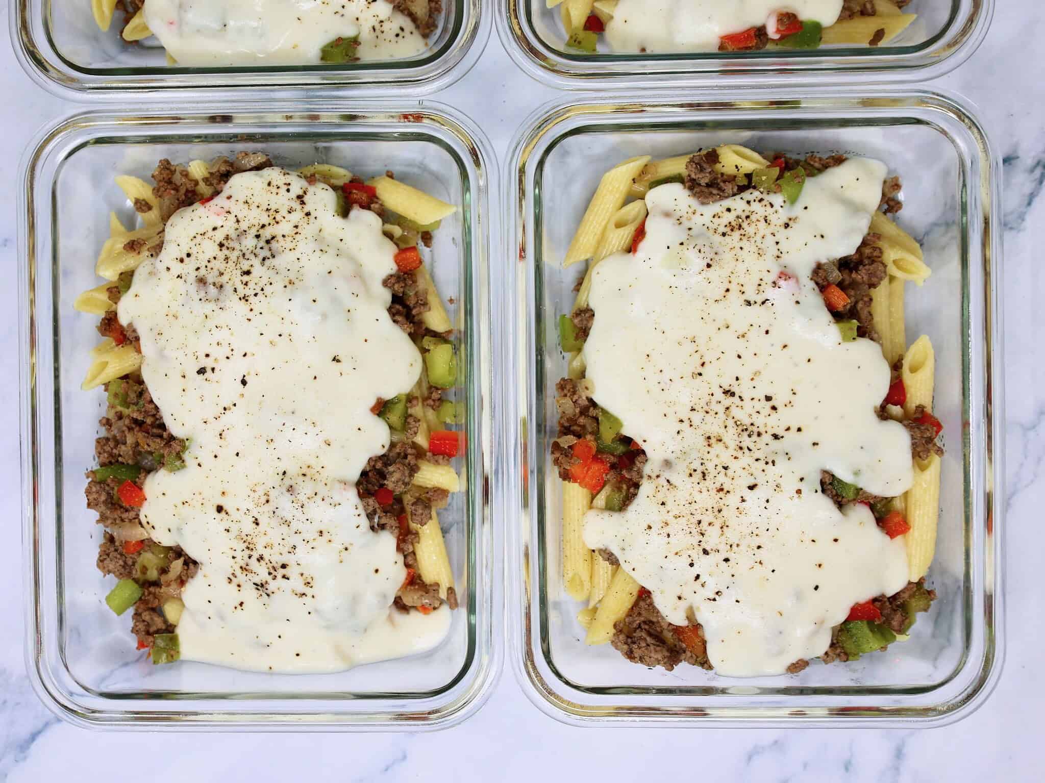 Overhead view of four Philly Cheesesteak Pasta Bowls ready for the refrigerator