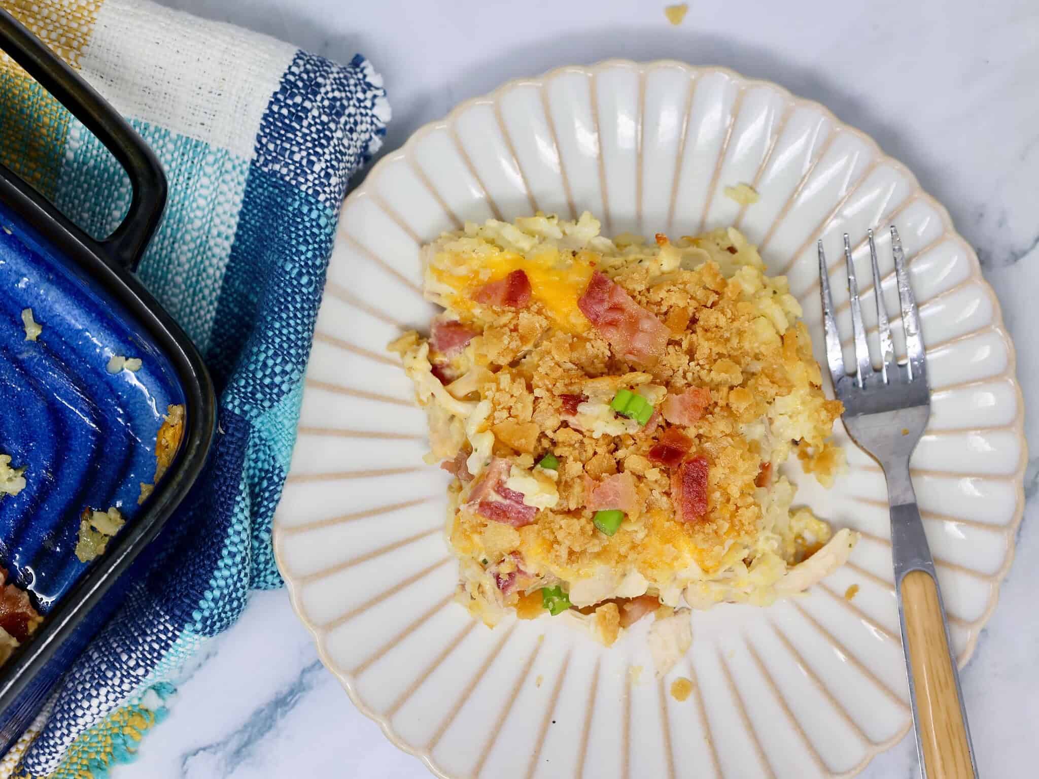 Close-up of crunchy Ritz cracker topping over creamy chicken bacon ranch casserole with rice.