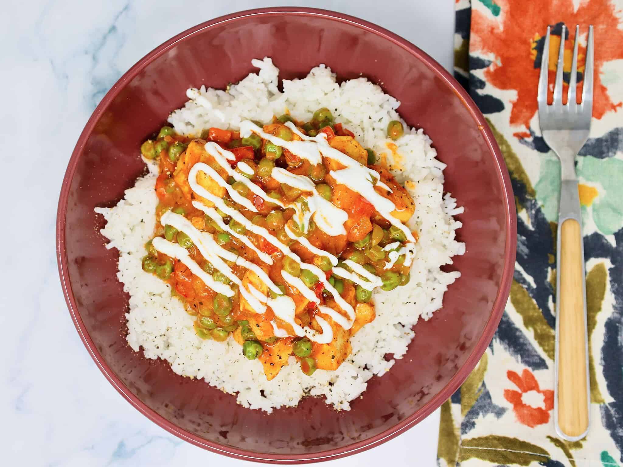 Tender chicken, peas, and peppers in creamy tikka masala sauce over rice are a perfect weeknight dinner