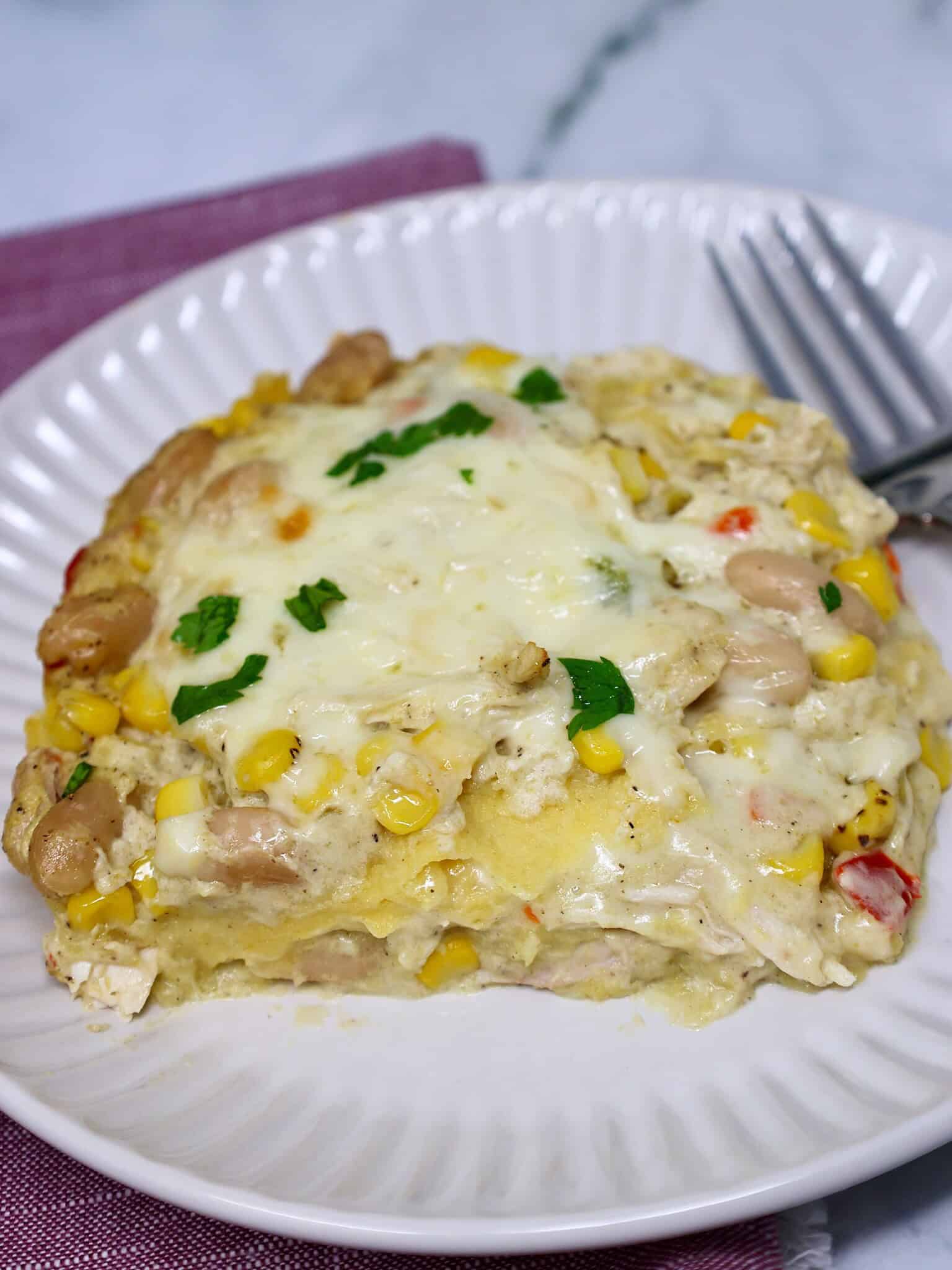 Serving of creamy chicken enchilada casserole with corn and white beans