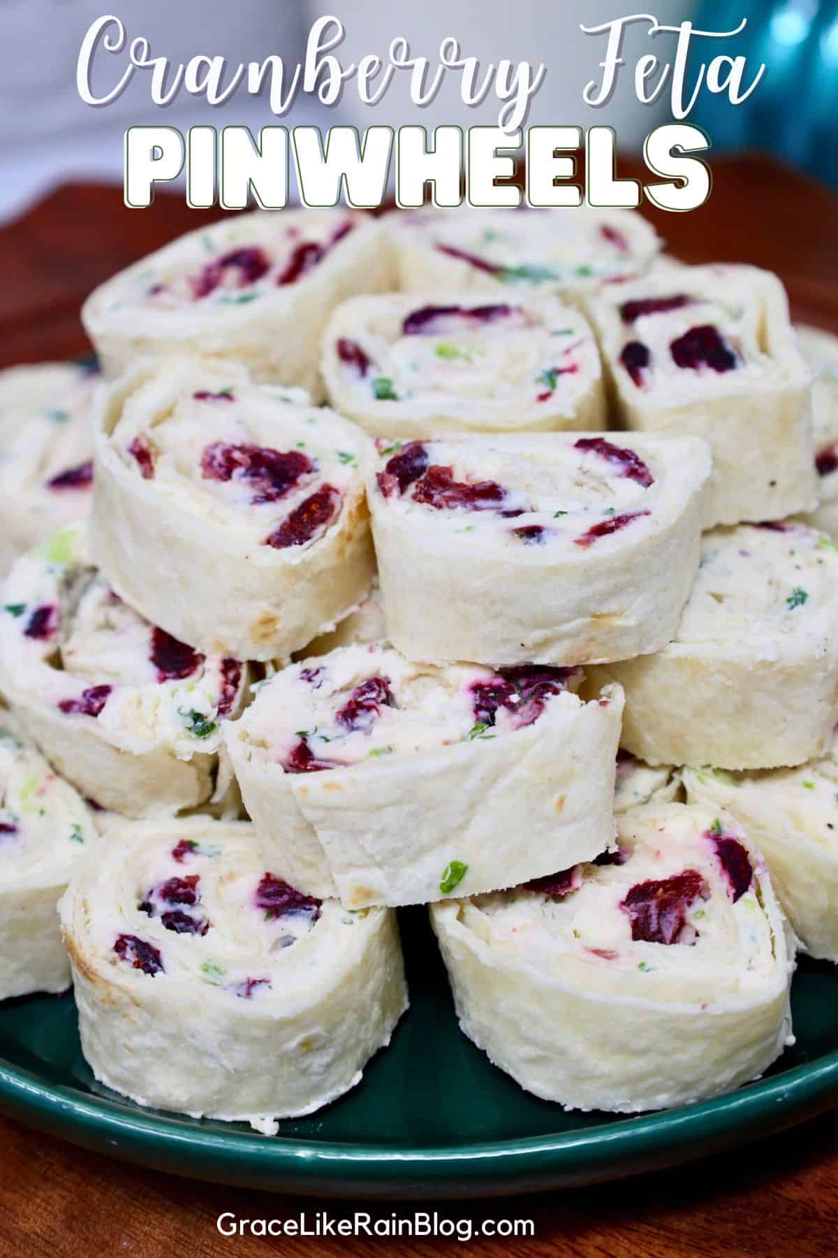 Cranberry feta pinwheels with cream cheese, dried cranberries, and fresh herbs arranged on a serving platter