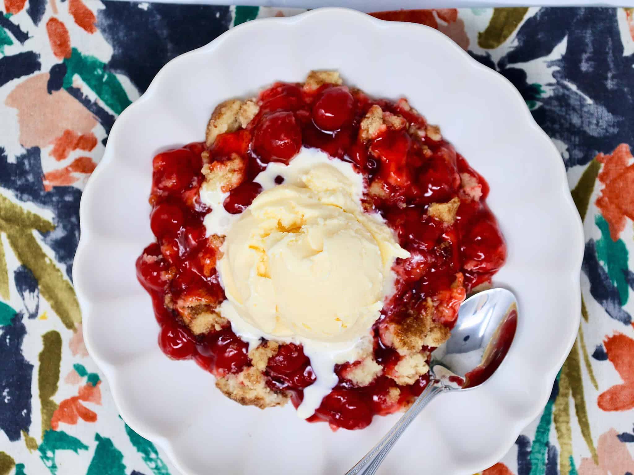 Close-up of buttery snickerdoodle cookie topping and bubbling red cherry filling in an easy cherry crisp.